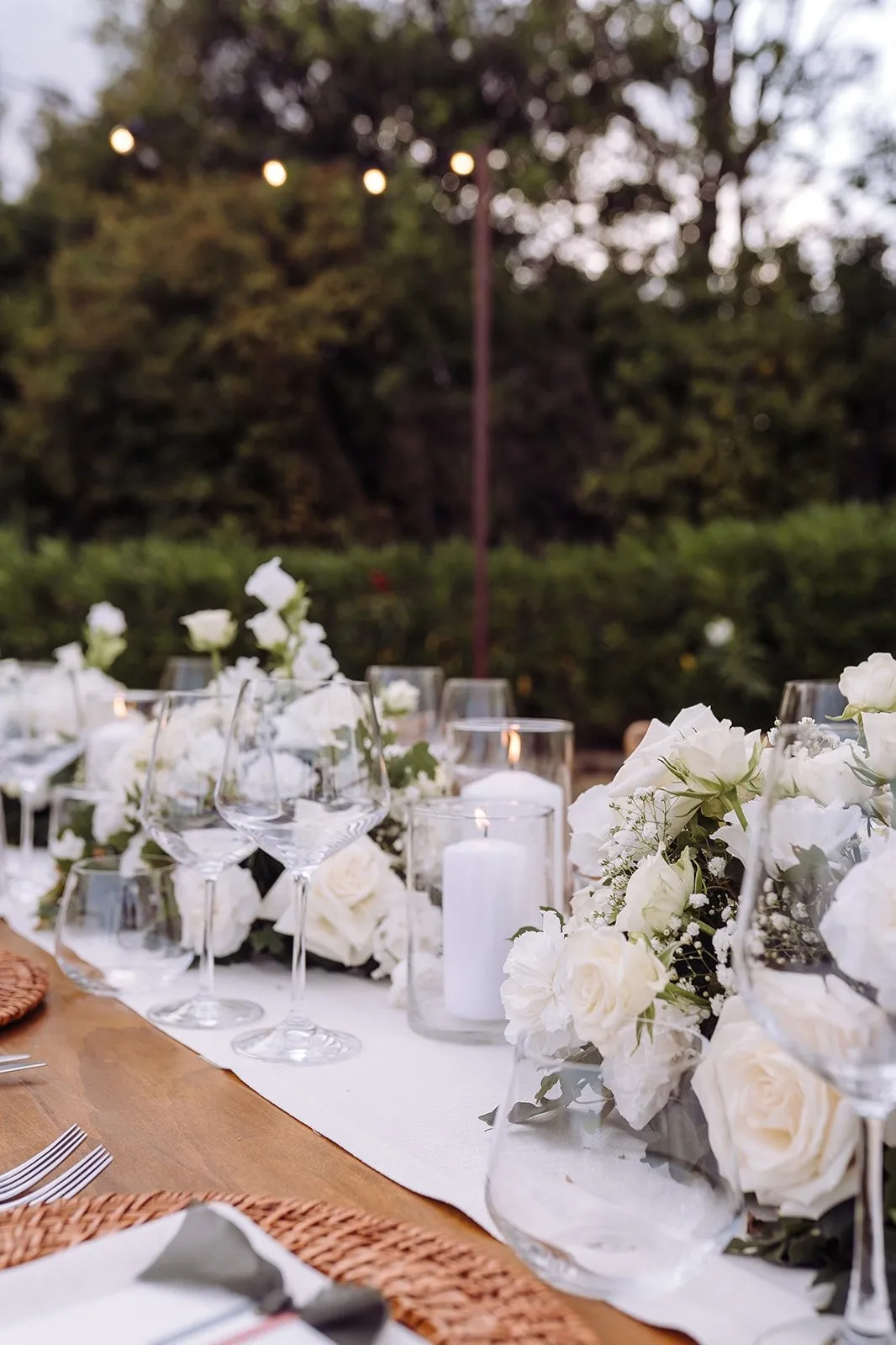 Mesa decorada com rosas brancas, velas e taças