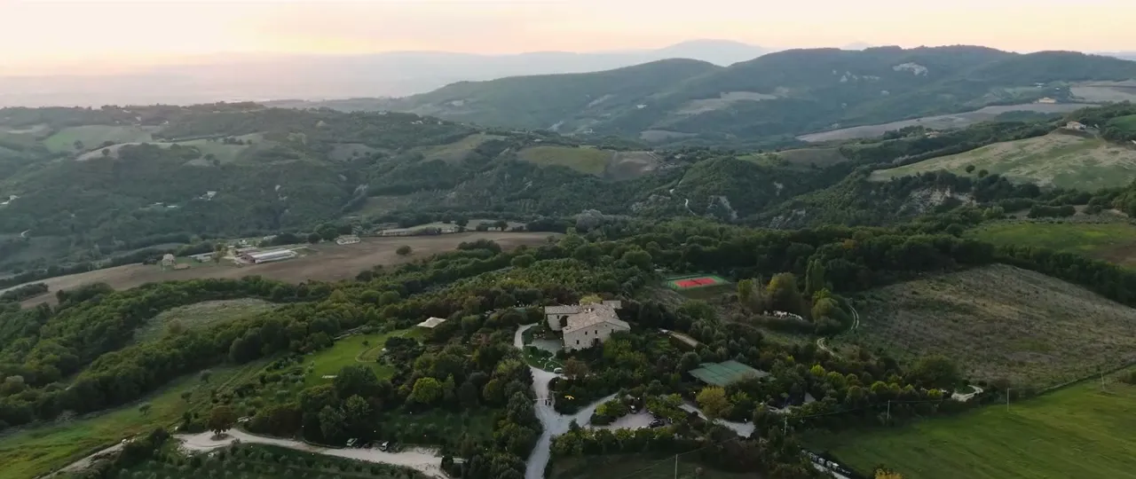 Vista aérea de uma villa entre as colinas da Itália ao entardecer